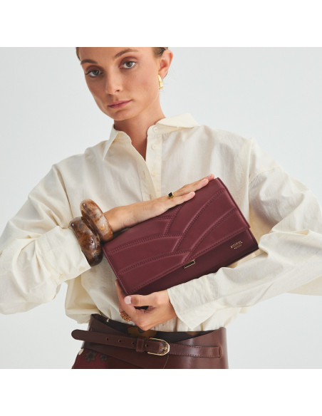 Pochette en cuir pour femme Venecia couleur bordeaux, tenue entre les mains, gros plan - MONPIEL Pochette en cuir pour femme Venecia couleur bordeaux, tenue entre les mains, gros plan - MONPIEL