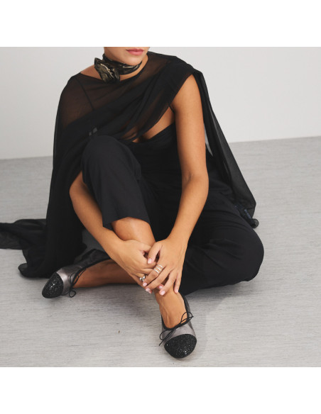 Valeria silver glitter-toe flat shoe, with leg crossed on the floor and hand resting, medium shot - MONPIEL