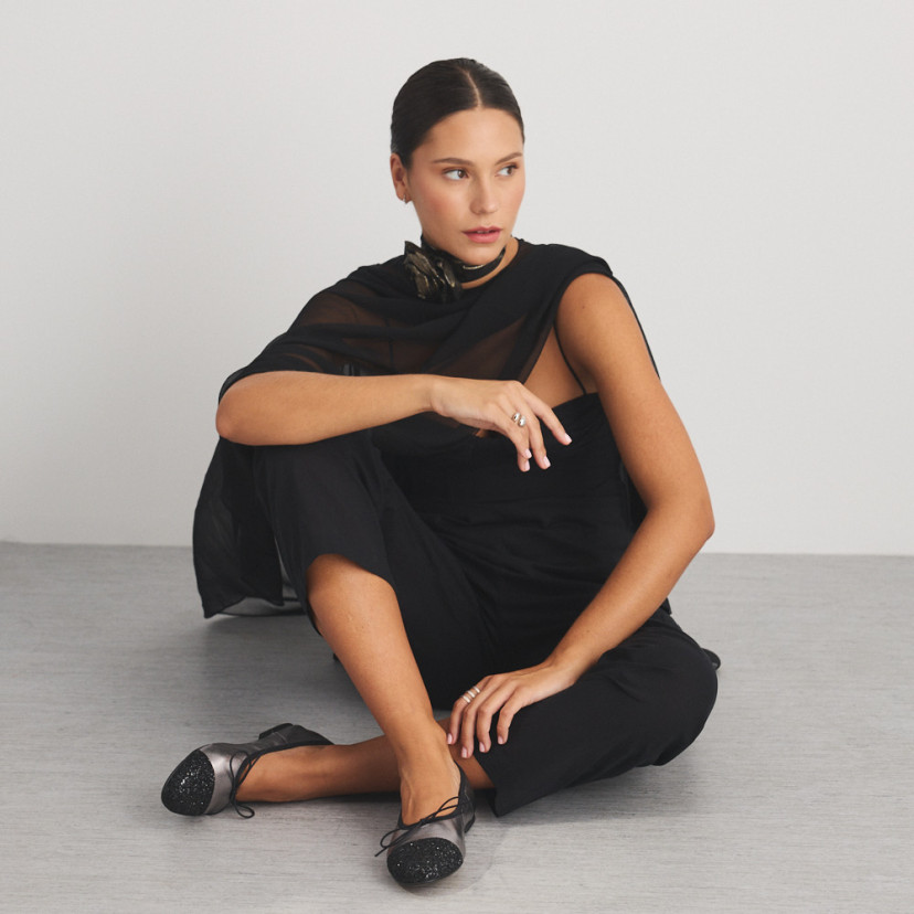 Valeria flat slipper with silver glitter toe, front view of model sitting on the floor, full shot - MONPIEL