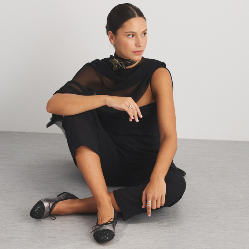 Valeria flat slipper with silver glitter toe, front view of model sitting on the floor, full shot - MONPIEL