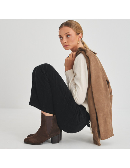 Bota de couro Marcela em camurça marrom, vista de perfil de modelo agachada - MONPIEL Bota de couro Marcela em camurça marrom, vista de perfil de modelo agachada - MONPIEL