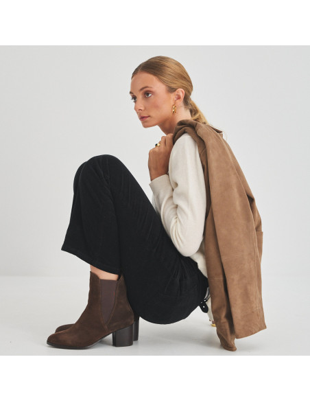 Bota de couro Marcela em camurça marrom, vista de perfil de modelo agachada - MONPIEL Bota de couro Marcela em camurça marrom, vista de perfil de modelo agachada - MONPIEL
