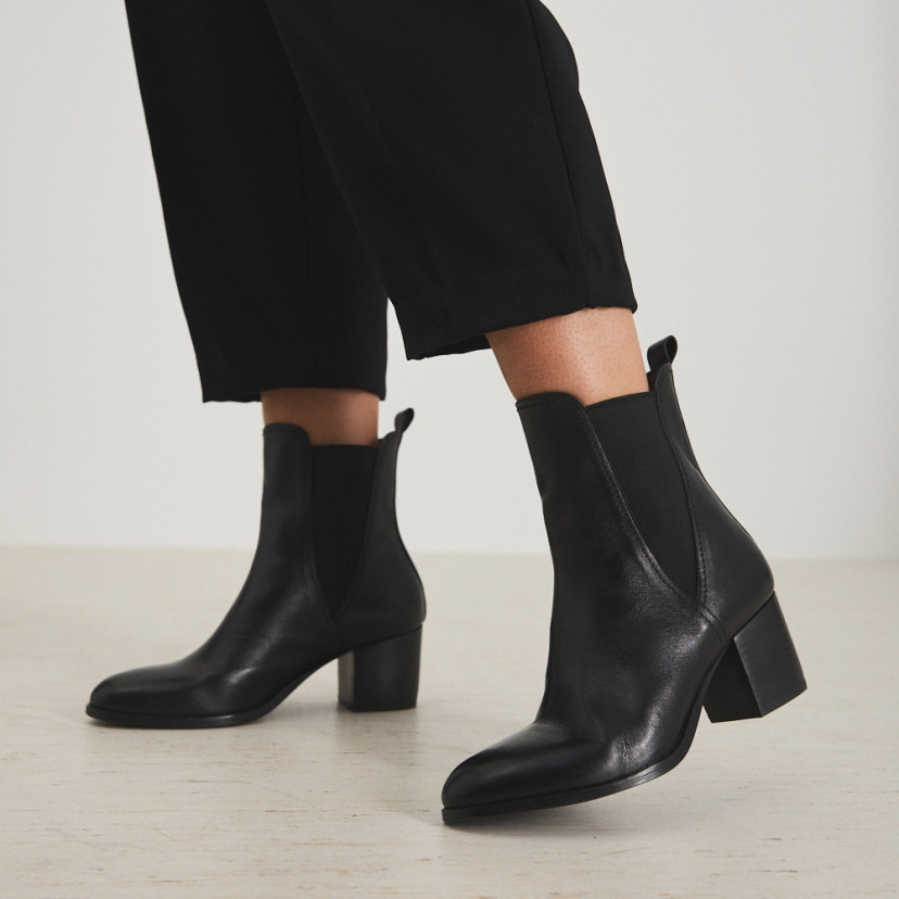 Marcela leather ankle boot in brown suede, mid shot with bucket bag held in hand - MONPIEL
