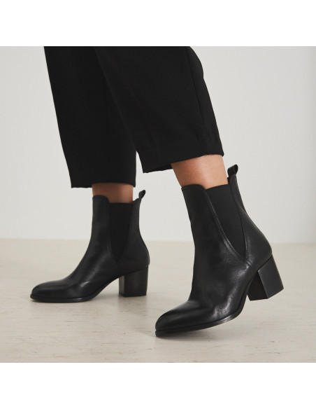 Bottine en cuir noir Marcela, vue en perspective, mettant un pied au premier plan - MONPIEL