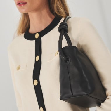 Bolso nudos pequeño de piel en color topo con vista frontal cogido con la mano por el asa - MONPIEL 2