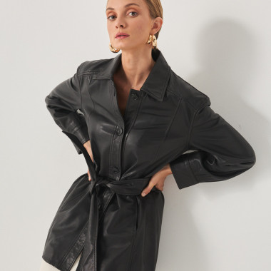Trench en cuir noir, modèle appuyé contre le mur, mains sur les hanches - MONPIEL 2