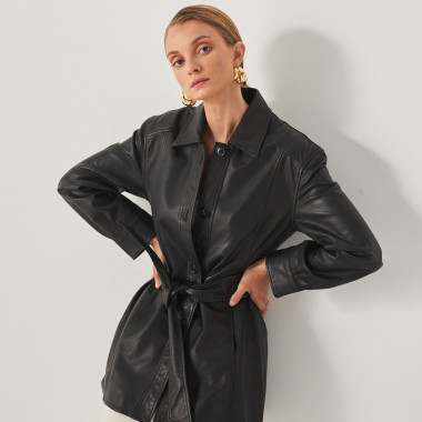 Black leather trench coat with hand-in-pocket detail, model mid shot - MONPIEL 2