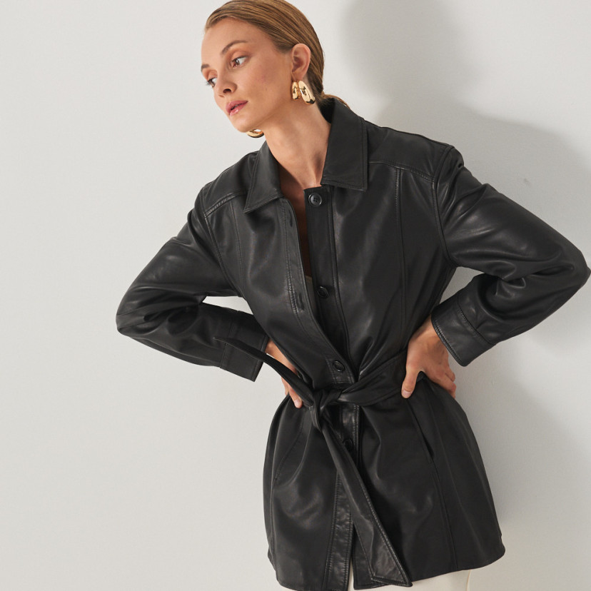 Trench de couro preto, vista frontal, modelo com as mãos na cintura - MONPIEL