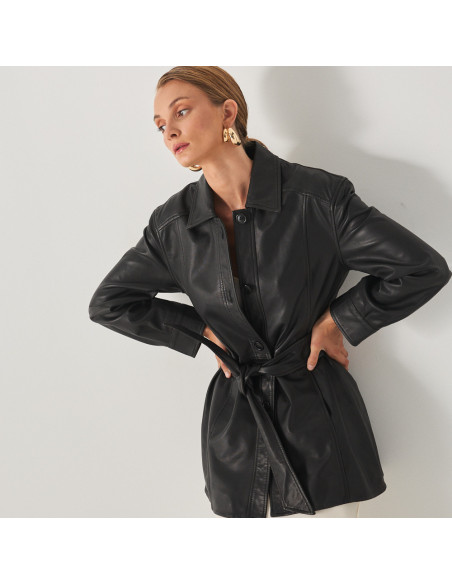 Trench en cuir noir, vue de face, modèle avec les mains sur les hanches - MONPIEL Trench en cuir noir, vue de face, modèle avec les mains sur les hanches - MONPIEL