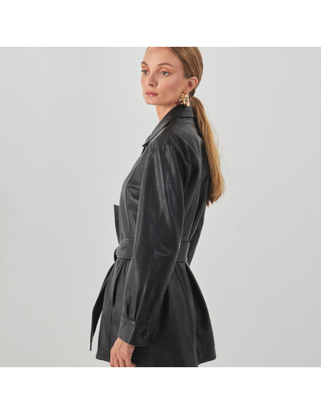 Black leather trench coat, profile view, against a white wall - MONPIEL