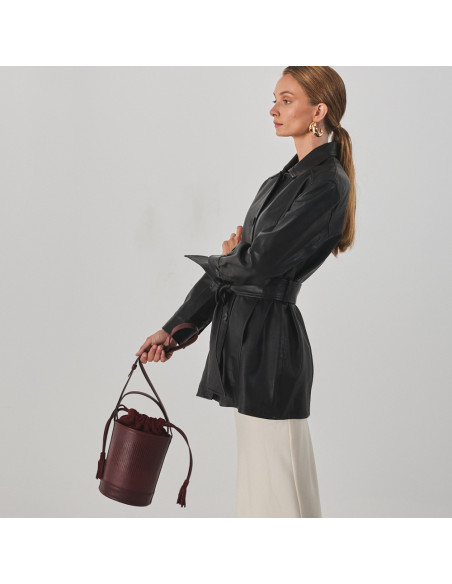 Bolsa bucket redonda pequena de couro em cor de serpente bordô, segurada pela alça longa, bolsa em movimento - MONPIEL