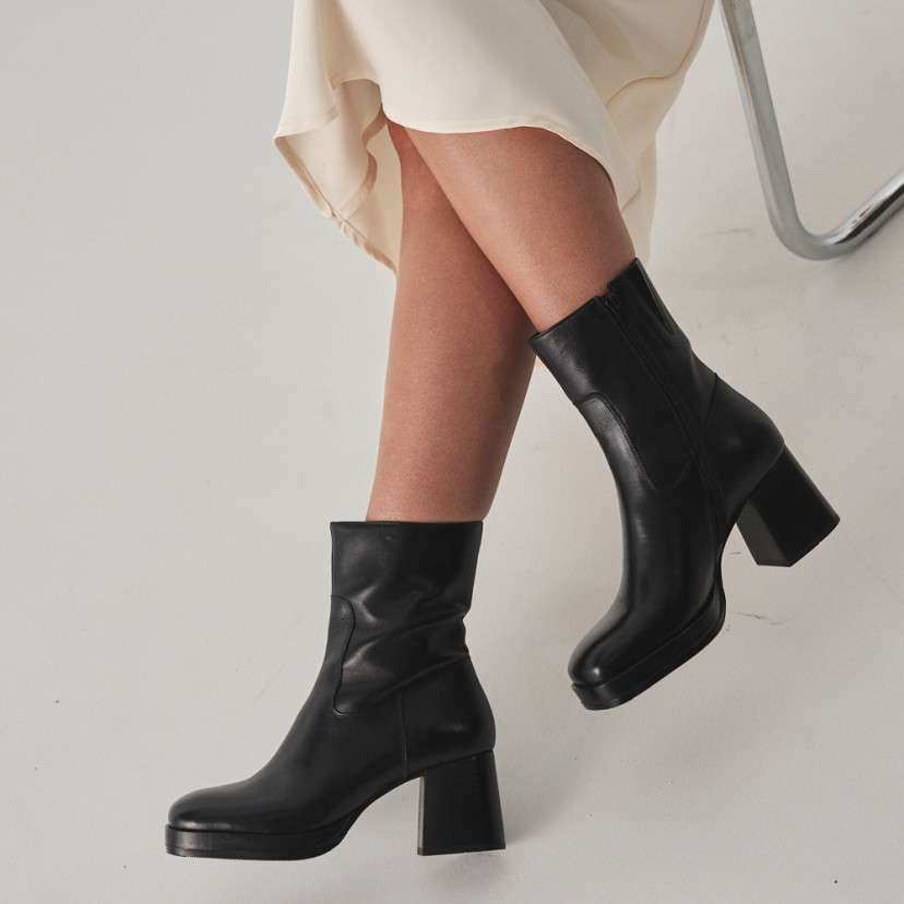 Claudia platform boot in black, side view, crossed legs close-up - MONPIEL