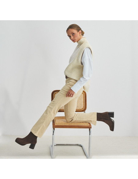 Botín de plataforma claudia en color marrón serraje con vista de perfil, modelo apoyando rodilla en la silla - MONPIEL