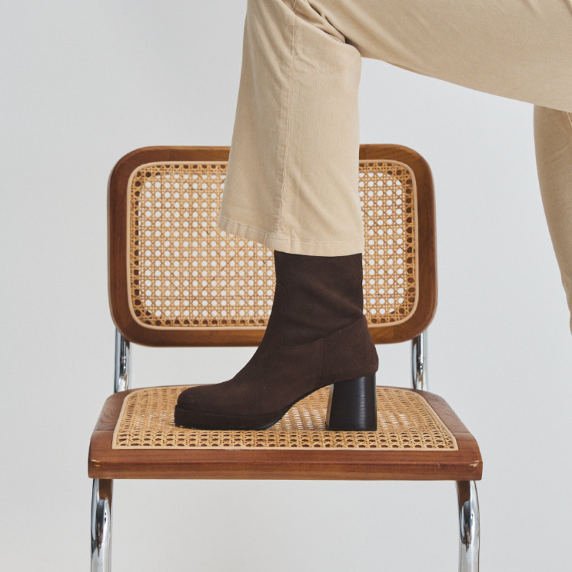 Claudia platform boot in brown suede, side view, foot resting on the chair - MONPIEL