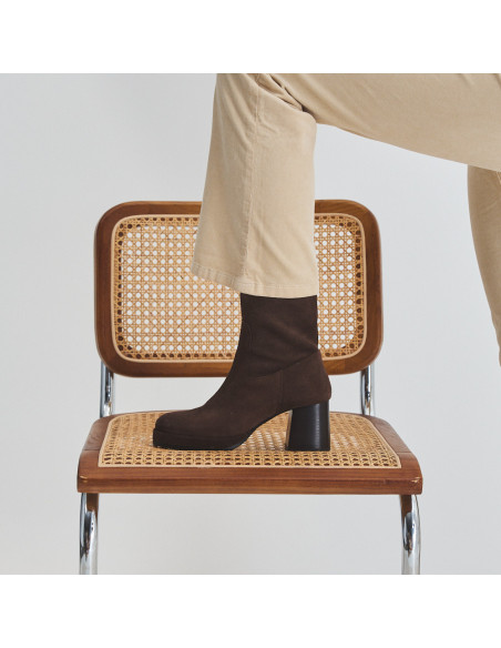 Claudia platform boot in brown suede, side view, foot resting on the chair - MONPIEL Claudia platform boot in brown suede, side view, foot resting on the chair - MONPIEL