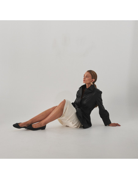 Manolita flat ballerina with stylized toe in black, full shot of model sitting on the floor - MONPIEL Manolita flat ballerina with stylized toe in black, full shot of model sitting on the floor - MONPIEL