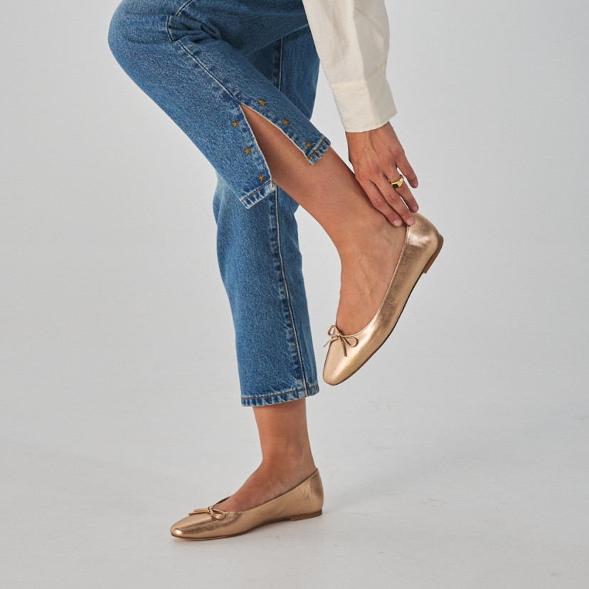 Manolita flat ballerina with stylized toe in metallic color, side view, bent knee close-up - MONPIEL