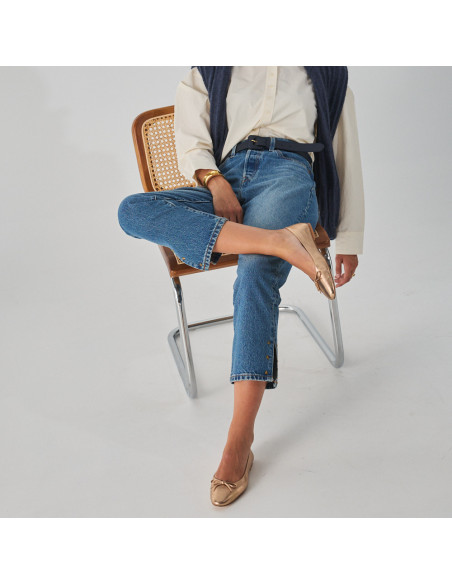 Manolita flat ballerina with stylized toe in metallic color, model sitting on the chair, overhead view, full shot - MONPIEL Manolita flat ballerina with stylized toe in metallic color, model sitting on the chair, overhead view, full shot - MONPIEL