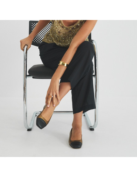 Sapato feminino com ponta quadrada de couro em cor ocre e bico preto, vista frontal do modelo sentado na cadeira com p - MONPIEL Sapato feminino com ponta quadrada de couro em cor ocre e bico preto, vista frontal do modelo sentado na cadeira com p - MONPIEL