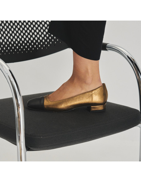 Sapato feminino com ponta quadrada de couro em cor ocre e bico preto, pé apoiado de perfil sobre a cadeira - MONPIEL Sapato feminino com ponta quadrada de couro em cor ocre e bico preto, pé apoiado de perfil sobre a cadeira - MONPIEL
