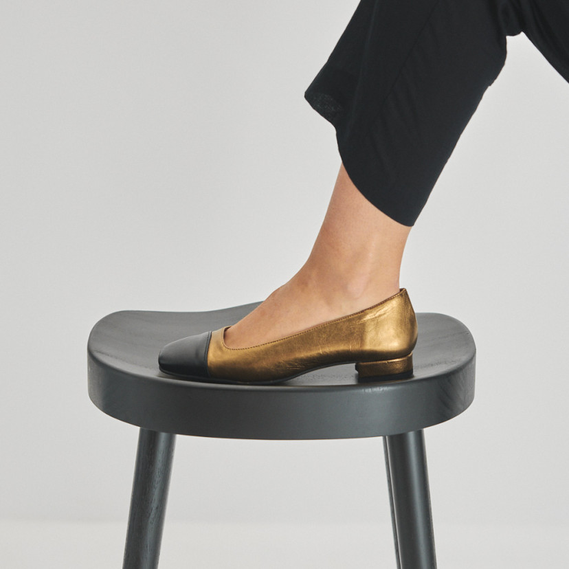 Sapato feminino com ponta quadrada de couro em cor ocre e bico preto, pé apoiado sobre o banquinho com vista de perfil - MONPIEL