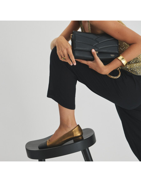 Sapato feminino com ponta quadrada de couro em cor ocre e bico preto, pé apoiado sobre o banquinho de perfil, com bols - MONPIEL Sapato feminino com ponta quadrada de couro em cor ocre e bico preto, pé apoiado sobre o banquinho de perfil, com bols - MONPIEL