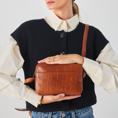 Krokodilleder Umhängetasche in braun, mit Umhängegriff in den Händen gehalten, Frontansicht - MONPIEL 2