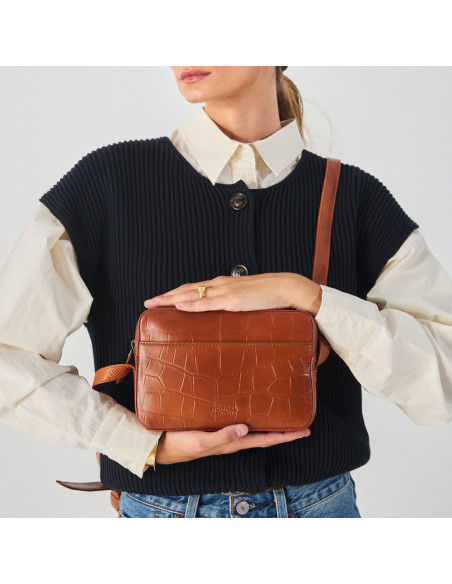Crocodile leather crossbody bag in brown, with crossbody handle held with hands, front view - MONPIEL