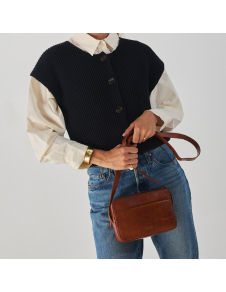 Crocodile leather crossbody bag in brown, with handle held in the hand, front view - MONPIEL