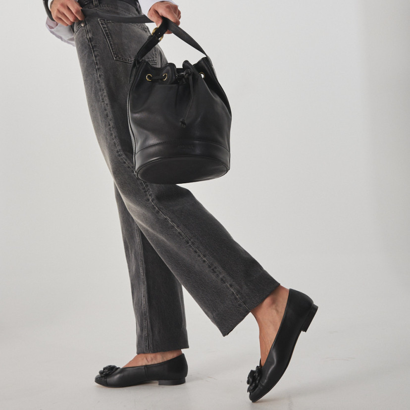 Ameliè patent leather ballerina with flower toe in black, walking with leather handbag in hand - MONPIEL