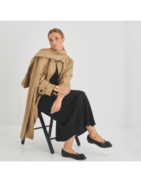 Ameliè patent leather ballerina with flower toe in black, perspective view, full shot of model sitting on the chair - MONPIEL