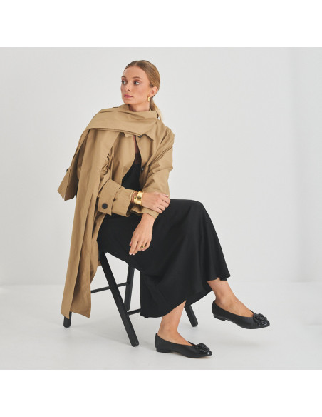 Ameliè patent leather ballerina with flower toe in black, perspective view, full shot of model sitting on the chair - MONPIEL