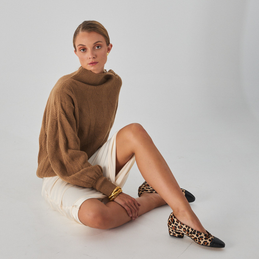Ballerina in leather with two-tone heel in animal print color, general shot of model sitting on the floor with leg in - MONPIEL
