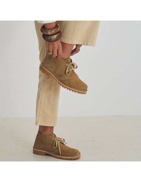 Botín de piel heidi en color arena con vista de perfil, rodilla flexionada hacia arriba - MONPIEL