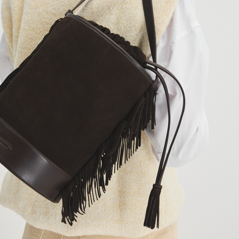 Leather bucket bag with large bangs in brown split leather, bangs detail in the foreground - MONPIEL