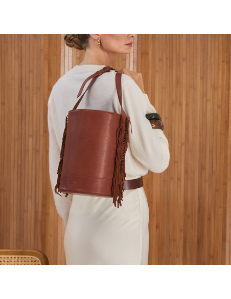 Large tan leather bucket bag with fringe, hanging on the back - MONPIEL
