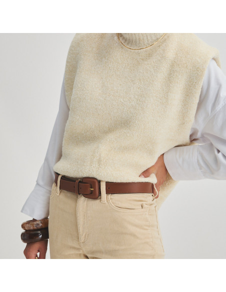 Brown leather belt with covered buckle, worn over corduroy pants, perspective view, model standing - MONPIEL Brown leather belt with covered buckle, worn over corduroy pants, perspective view, model standing - MONPIEL