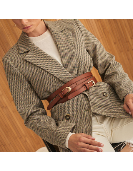 Cintura a doppio giro in pelle color cuoio, vista frontale su giacca a pied-de-poule, modello seduto - MONPIEL Cintura a doppio giro in pelle color cuoio, vista frontale su giacca a pied-de-poule, modello seduto - MONPIEL