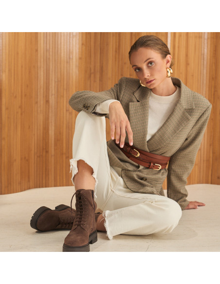 Camila-Lederstiefelette in braunem Wildleder mit Schnürung, Gesamtaufnahme des Modells, das auf dem Boden sitzt - MONPIEL Camila-Lederstiefelette in braunem Wildleder mit Schnürung, Gesamtaufnahme des Modells, das auf dem Boden sitzt - MONPIEL