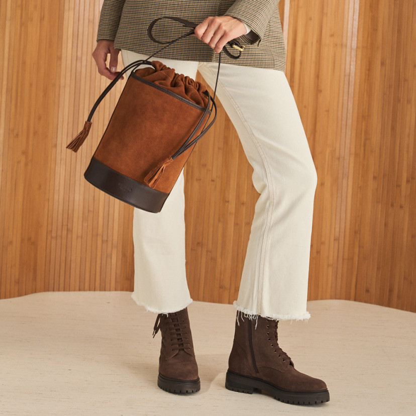 Round cube-shaped leather bag in suede leather color in motion, held with the hand - MONPIEL