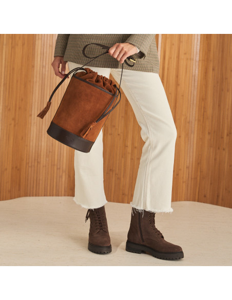 Bolso redondo en forma de cubo de piel en color serraje cuero en movimiento cogido con la mano - MONPIEL