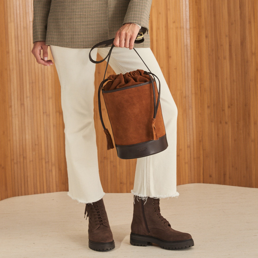 Round cube-shaped leather bag in suede leather color, held with the hand, front view - MONPIEL
