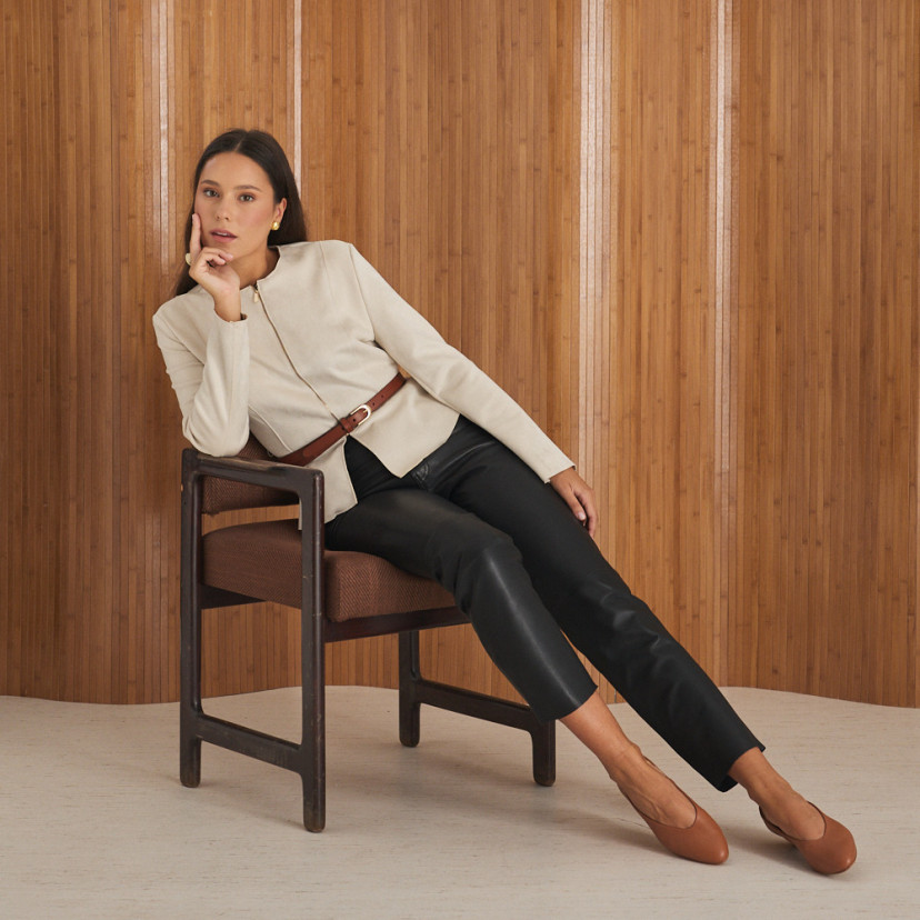 Bailarina de couro com salto na cor couro, modelo sentada na poltrona com pernas esticadas, plano geral - MONPIEL