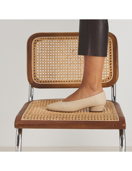 Ballerina con tacco in pelle beige, piede appoggiato sulla sedia, vista di profilo, dettaglio del tacco - MONPIEL Ballerina con tacco in pelle beige, piede appoggiato sulla sedia, vista di profilo, dettaglio del tacco - MONPIEL