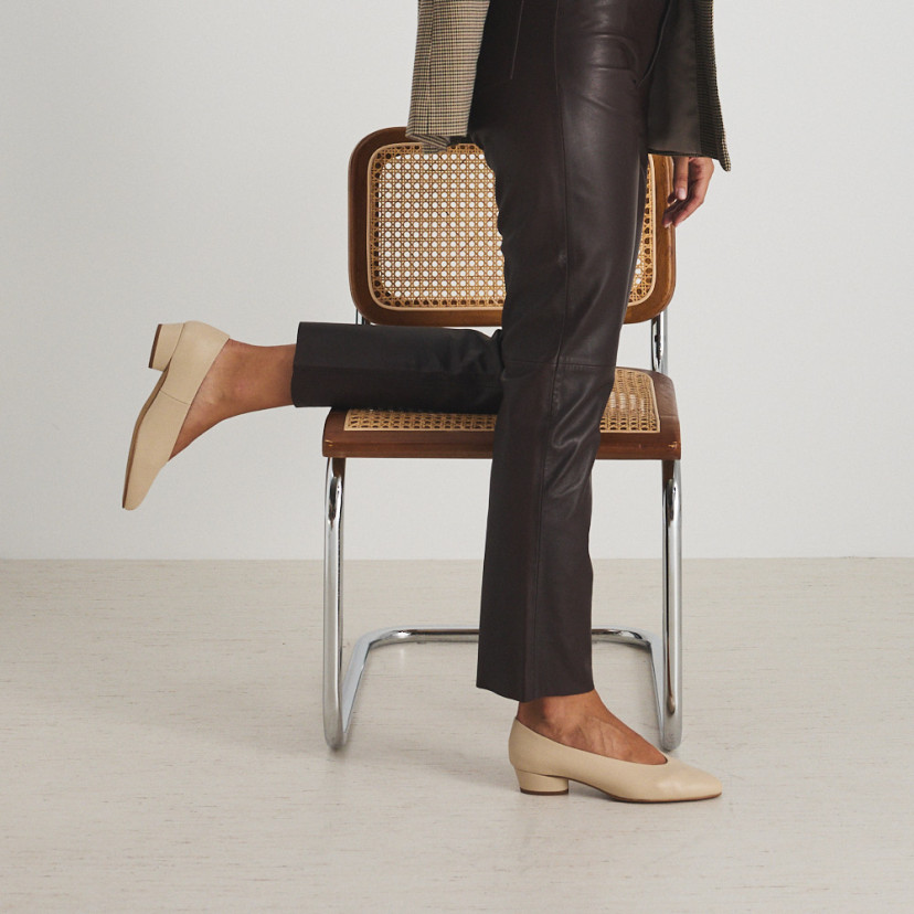 Beige heeled ballerina with knee resting on the chair, side view - MONPIEL