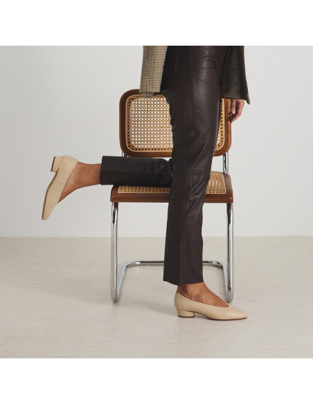Beige heeled ballerina with knee resting on the chair, side view - MONPIEL Beige heeled ballerina with knee resting on the chair, side view - MONPIEL