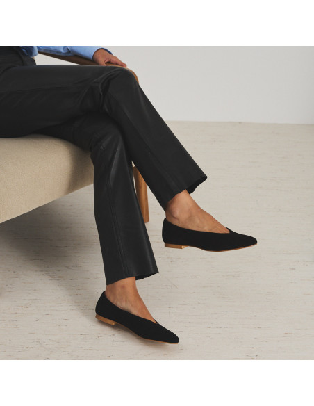 Black suede flat ballet shoe, profile view, model sitting on an armchair - MONPIEL