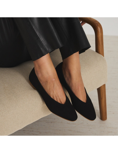 Black suede flat ballet shoe, feet raised on the armchair, close-up perspective view - MONPIEL