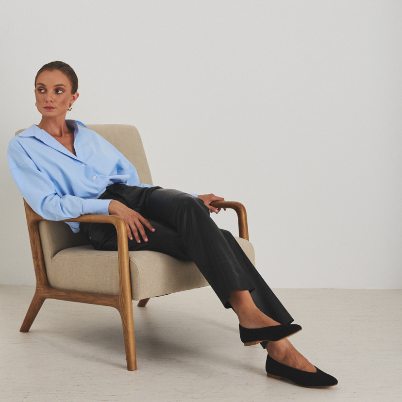 Calça de couro preta, modelo sentada na poltrona, plano geral - MONPIEL