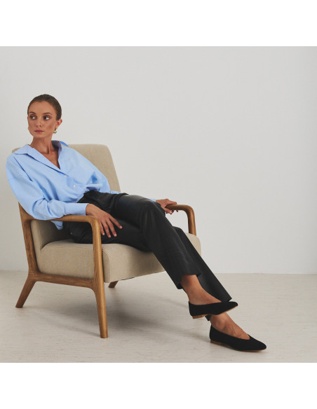 Pantalon en cuir noir, modèle assis sur le fauteuil, plan large - MONPIEL